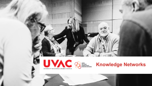 People seated around a table with UVAC associate standing talking to one woman